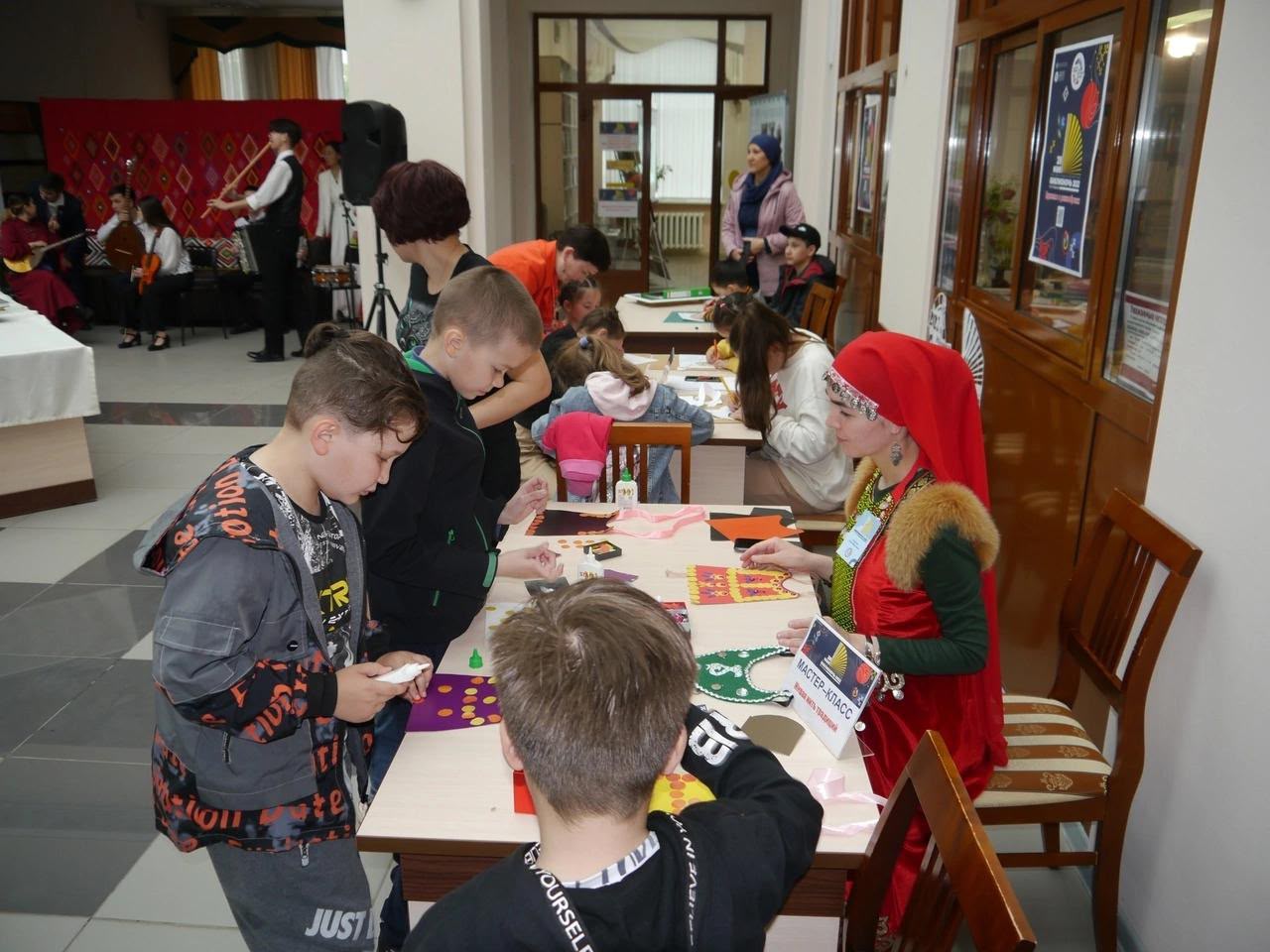 Зухра в национальном костюме с детьми за столом